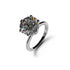 A round brilliant-cut gemstone solitaire ring in a polished silver-tone setting, shown on a clean white background with a soft shadow.